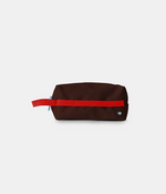 A dark brown nylon pouch with a bright red horizontal stripe and a matching red loop handle, shown on a light gray background.