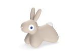 Beige rabbit-shaped toy with a blue eye on a white background