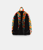A backpack shown from the back, featuring a black padded back panel and straps, with a colorful abstract patterned fabric on the top and sides.