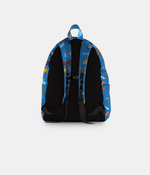 A backpack shown from the back, featuring a blue fabric body with a colorful cartoon space-themed print, black padded back panels, and black straps, set against a light gray background.