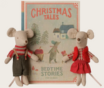 On a white background, two plush mice in front of a box shaped like a storybook that says "christmas tales" on the front.