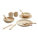 Set of beige dishes with wooden utensils on a white background