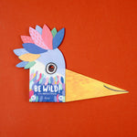 Colorful bird mask packaging with 'Be Wild!' text on an orange background