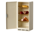 Beige refrigerator with ice cream cones and a cake on a white background
