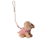 Stuffed animal toy with a pink outfit and strap on a white background