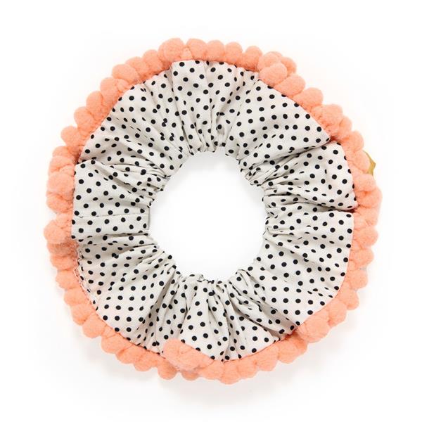 on a white background, a white scrunchie with small black dots and a scalloped coral trim