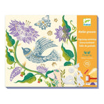 A craft box on a white background featuring engraved stamps collages of flowers and birds in blue, purple and green on a yellow background.