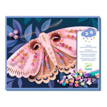 Box of a craft kit with a pink moth design and colorful beads on a blue background