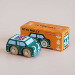 Dark green toy car with Union Jack flag next to its orange packaging box on a beige background