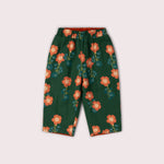 Green pants with orange floral pattern on a light gray background