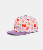 A pink snapback cap with a colorful floral pattern on the crown and a solid purple flat brim, shown against a light gray background.
