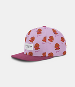 A light purple snapback cap with a repeating pattern of brown cartoon dogs and the word 'Cute' on the front panels, featuring a solid dark purple flat brim and a white 'HEADSTER' brand patch on the front.