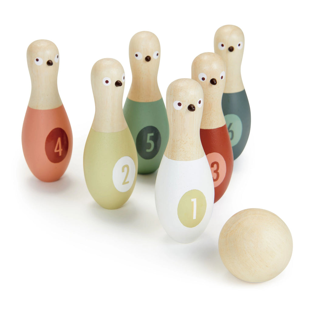 On a white background, 6 bowling pins with numbers on them, and faces with beaks to make them look like birds. A wooden ball ins in front of the pins.