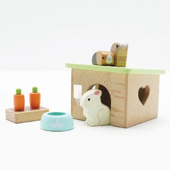 Wooden toy set with a hamster-like figure, a box, and small carrots on a white background