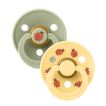 Two baby pacifiers with ladybug design on a white background