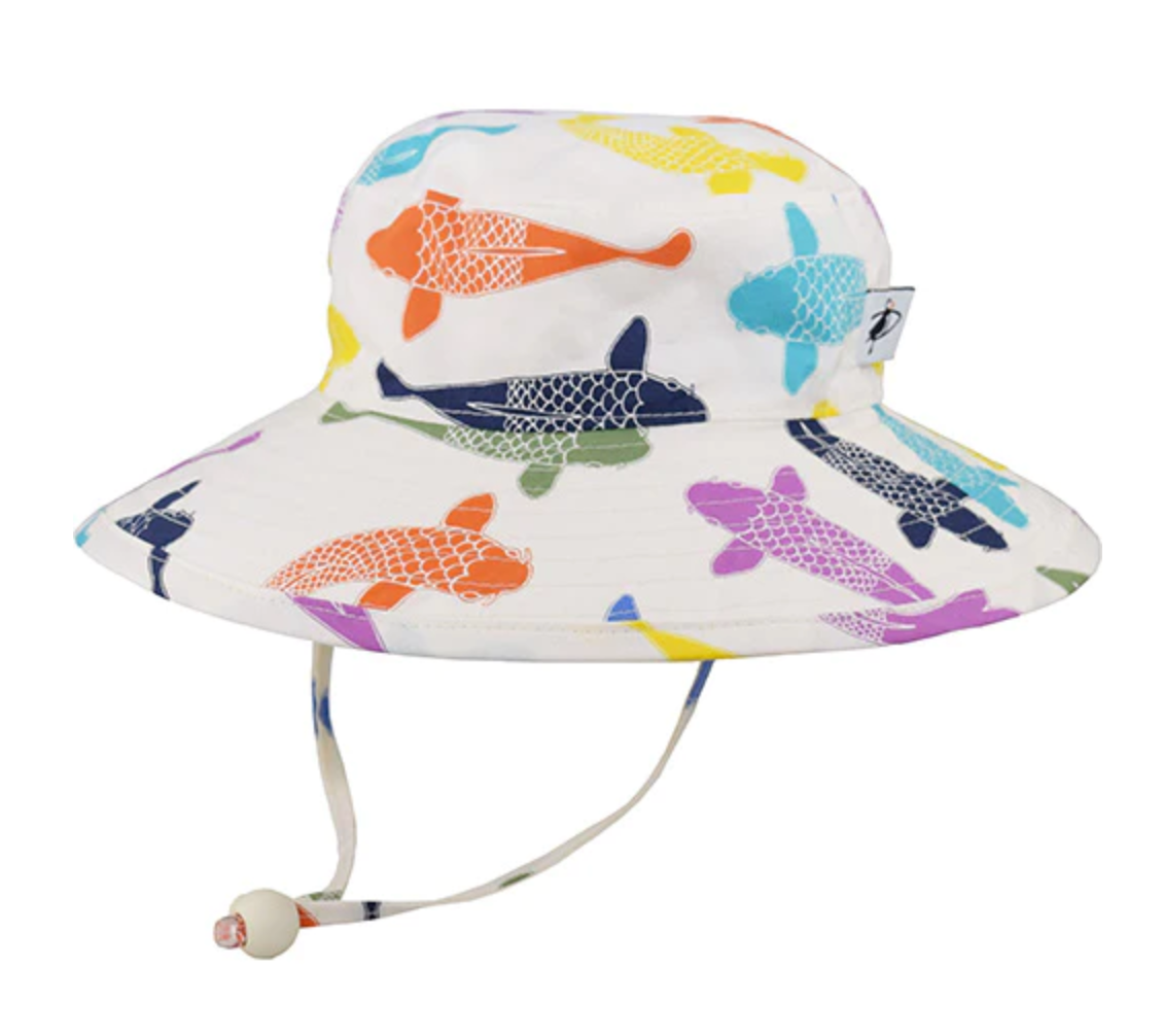 A white sunhat with a wide brim and a strap that hangs down with a toggle tie on a white background. Different colors of large koi fish are all over the hat