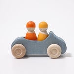 on a white background, a blue wooden convertible car with two peg dolls inside, one yellow, one orange