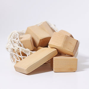 a bag of natural wooden blocks in a net bag in a white setting.