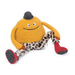 On a white background, a plush round charater with a small black sparkly bowler hat and leopard print soft pants, red boots, two eyes and a wide embroidered smile. 
