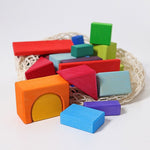 Some brightly coloured blocks in a pile on a white background. A net bag sits behind them.