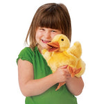 Alittle brown haired girl with bangs hugging a yellow plush duckling