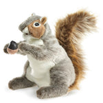 A plush squirrel holding an acorn on a white background