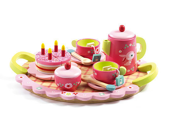 on a white background, a pink and green wooden tea set on a tray with two cups, teabags, spoons, a cake with candles, a teapot and a covered sugar dish
