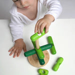 A baby playing with the stacking tree on a white background.