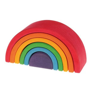a wooden rainbow with 6 nesting arcs on a white background. The largest outer arc is red, then each smaller arc is in rainbow order until the last solid peice which is purple. 