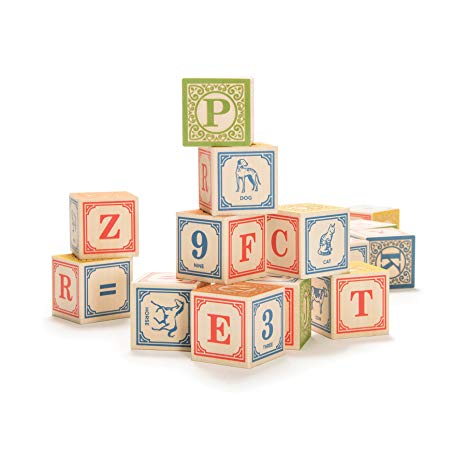 A set of upper case alphabet blocks stacked haphazardly on a white background. Some blocks show animals, some letters, some numbers with different colours on each face.