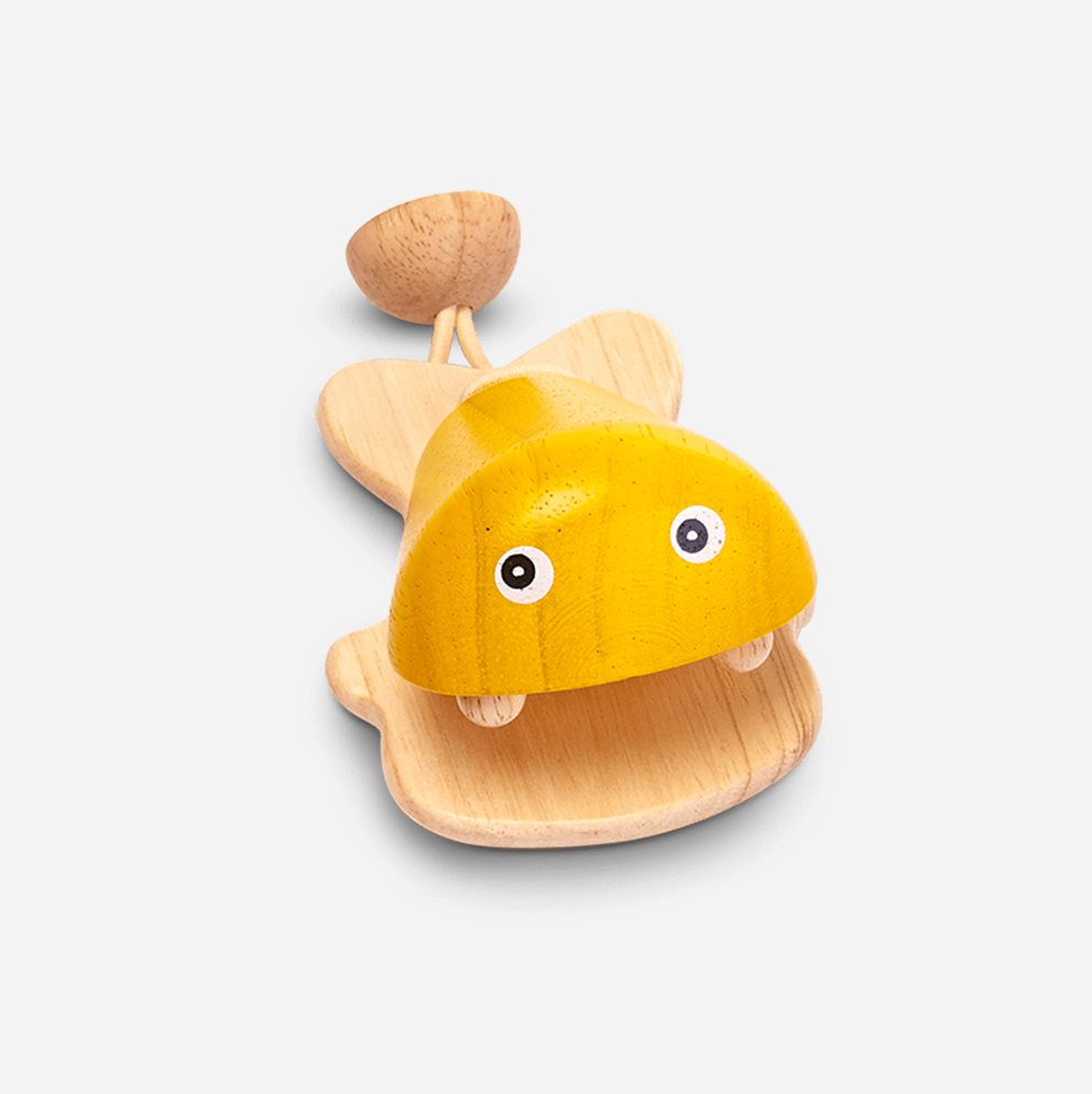 A wooden percussion instrument shaped like a fish with a blue body and beige fins and face details.